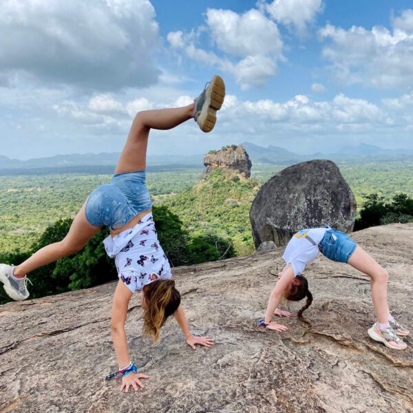 Twee kinderen op de Pidurangala Rots met uitzicht op de Leeuwenrots van Sigiriya tijdens een familiereis door Sri Lanka